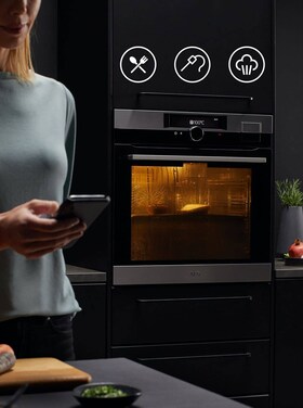 Kvinde laver mad ved hjælp af WiFi på telefon