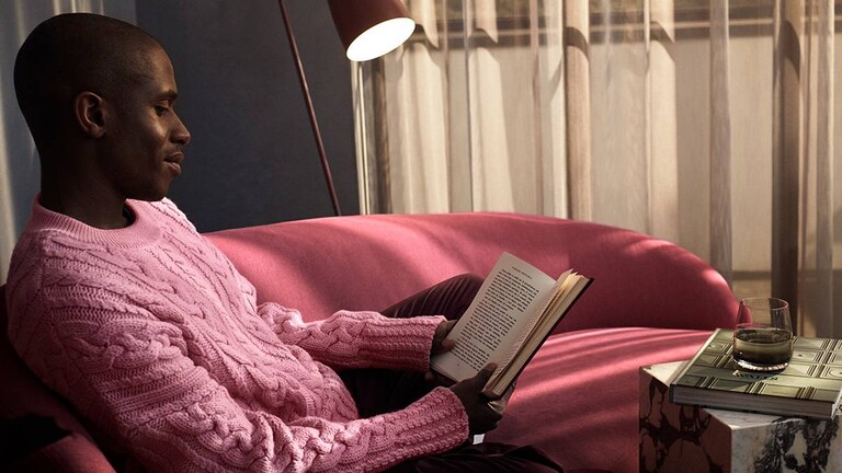 Mand sidder og læser i sofaen