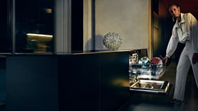 Kvinde der tømmer opvaskemaskine