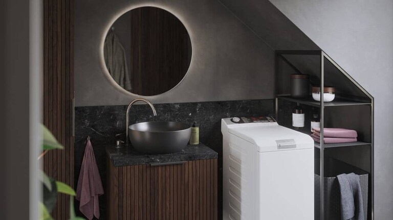 Topbetjent AEG vaskemaskine i et badeværelse.