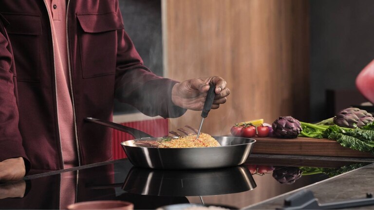 Mand laver mad på et komfur.