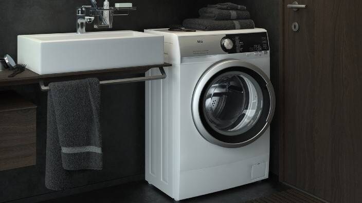 En kompakt vaskemaskine i et lille badeværelse.