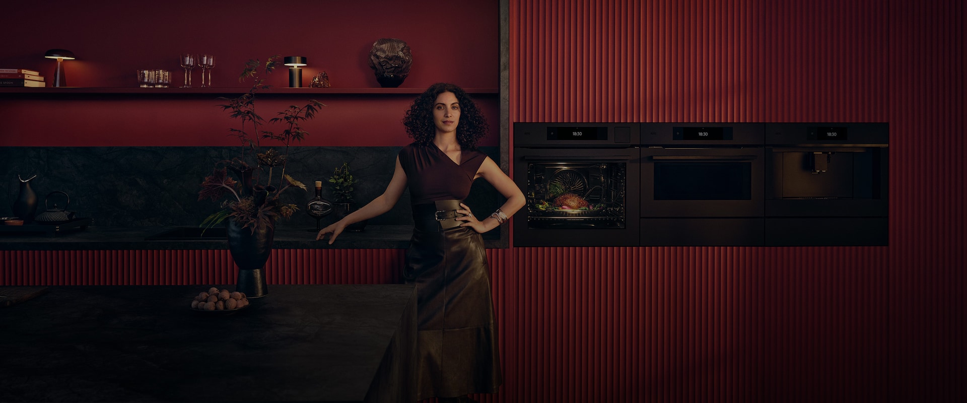 En kvinde står foran en ovn.