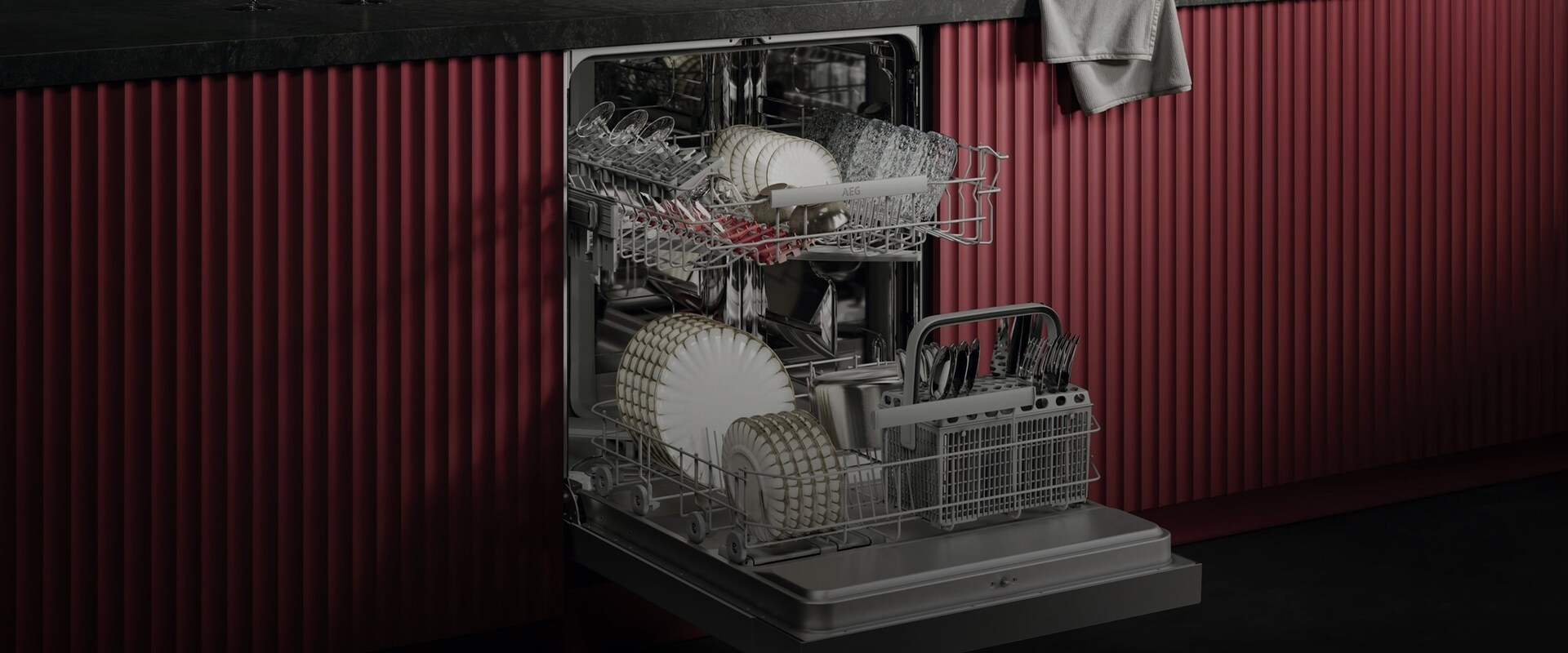 Åben AEG-opvaskemaskine som viser at der er masser af plads til tallerkener, glas og bestik. 