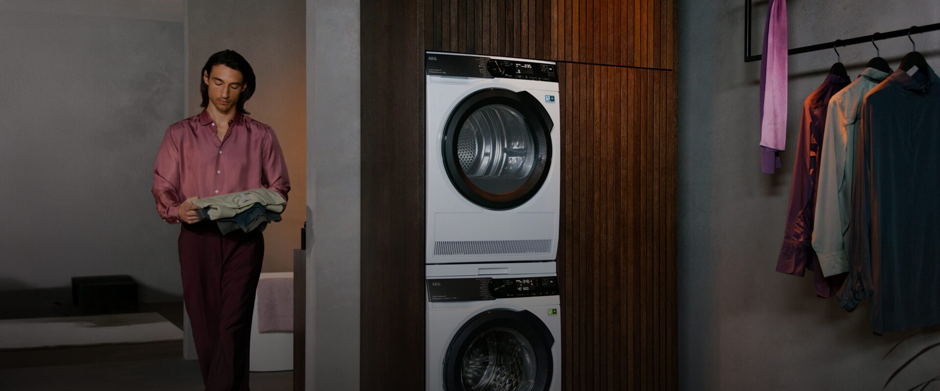 En tørretumbler står oven på en vaskemaskine i et rum.